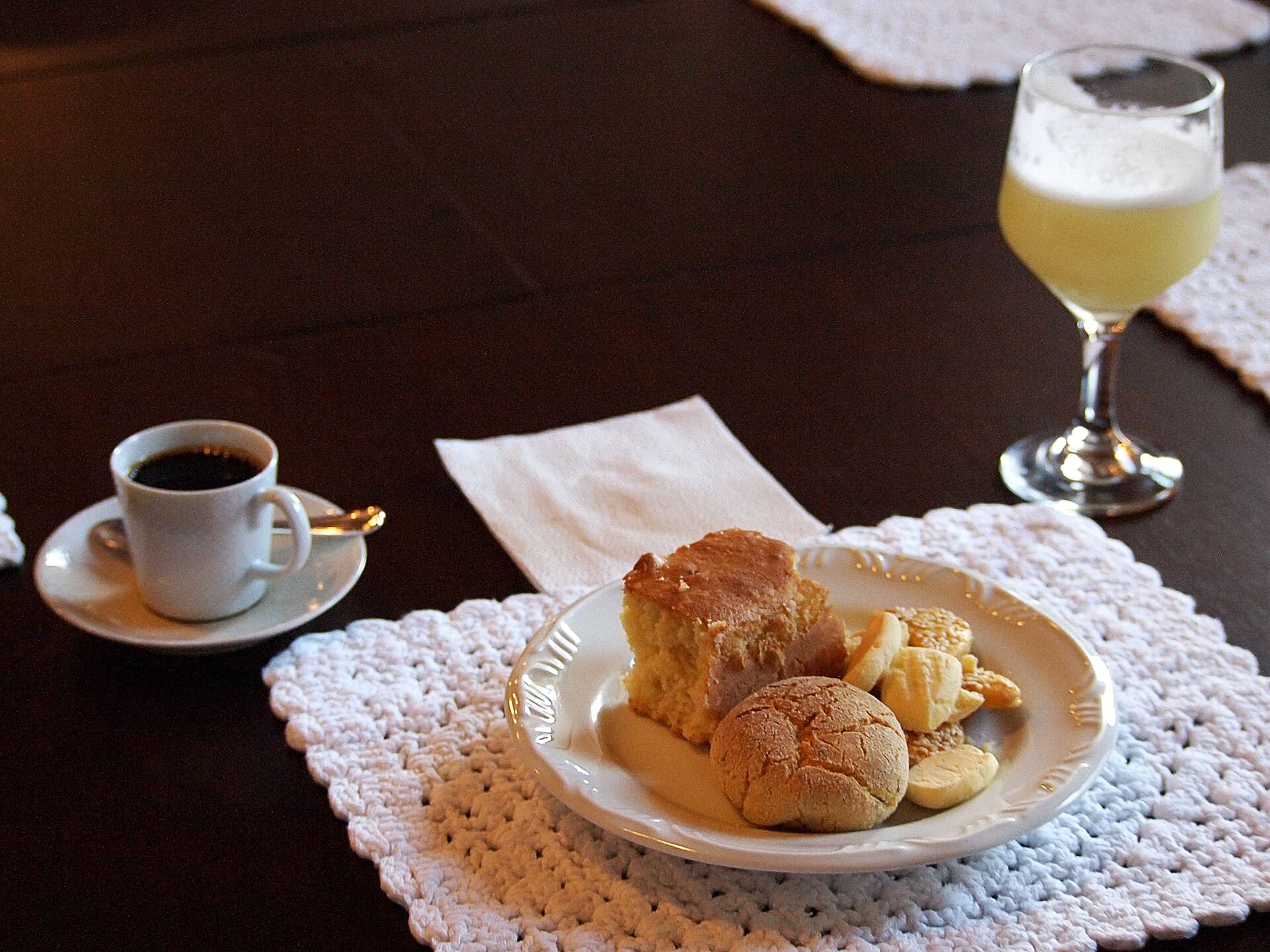 Café, bolo e biscoitos servidos em uma mesa de fazenda