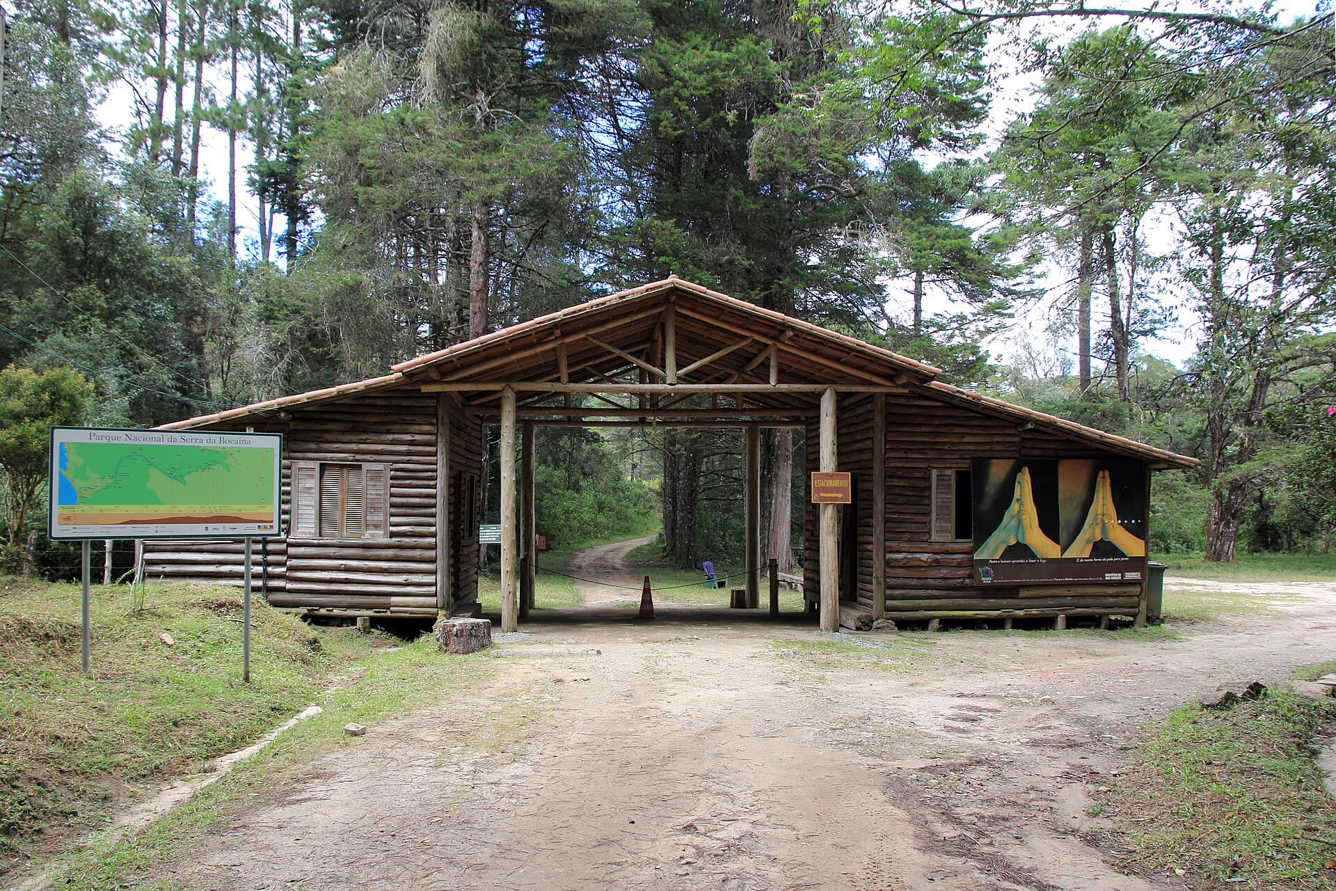 Portaria de madeira rústica na entrada do Parque Nacional da Serra da Bocaina, com mapa e estrada de terra